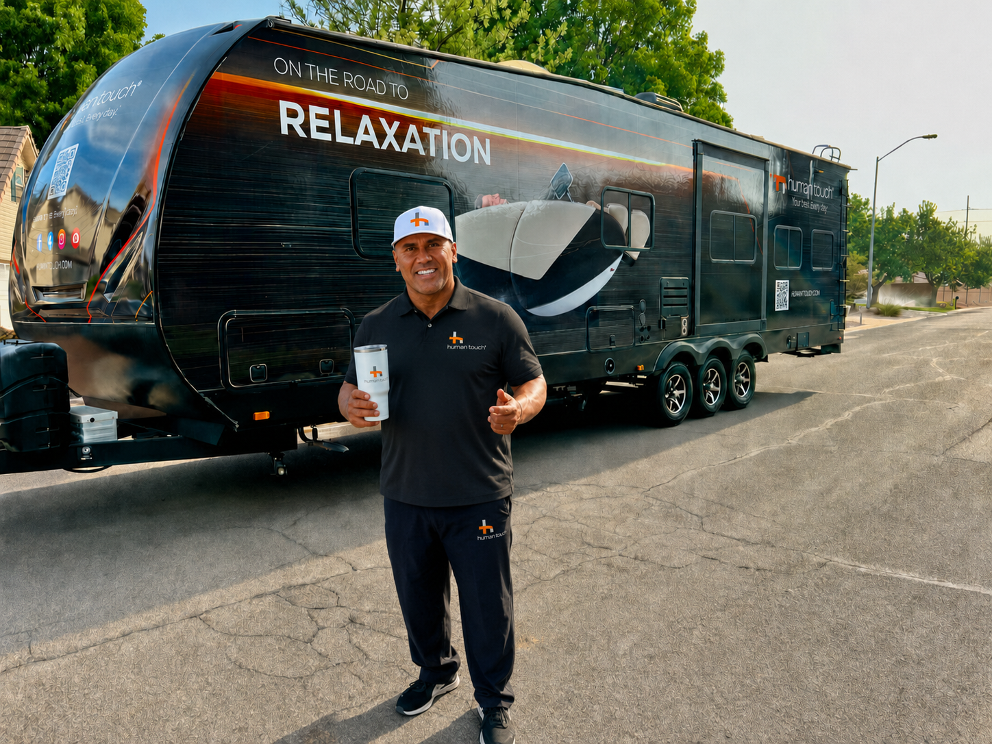 Human Touch team member standing in front of the branded black Recovery Lounge trailer